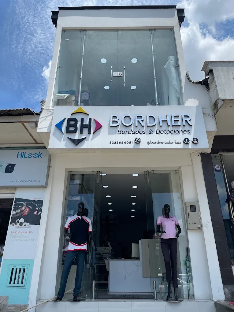Frente del local de Bordher Bordados y Dotaciones en el Centro de Villavicencio, con el letrero BH y vitrina con uniformes