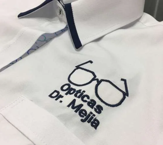 Polo blanco con logo de óptica bordado en el pecho